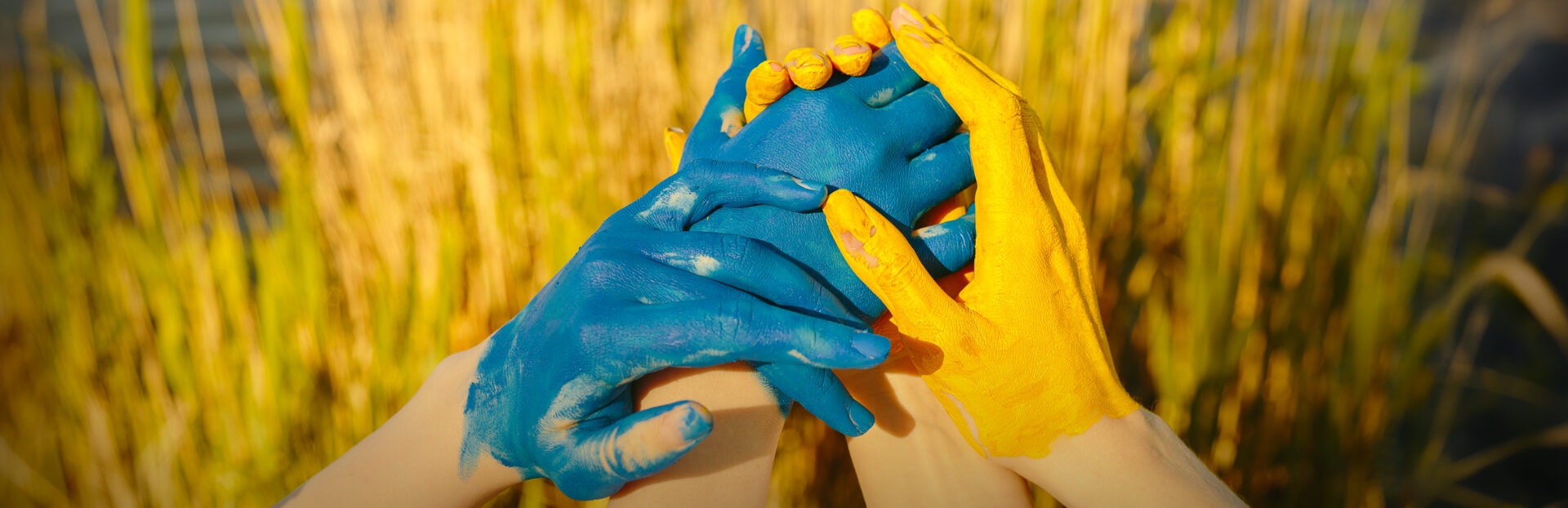 Girls' hands painted in Ukrainian flag colors, blue and yellow